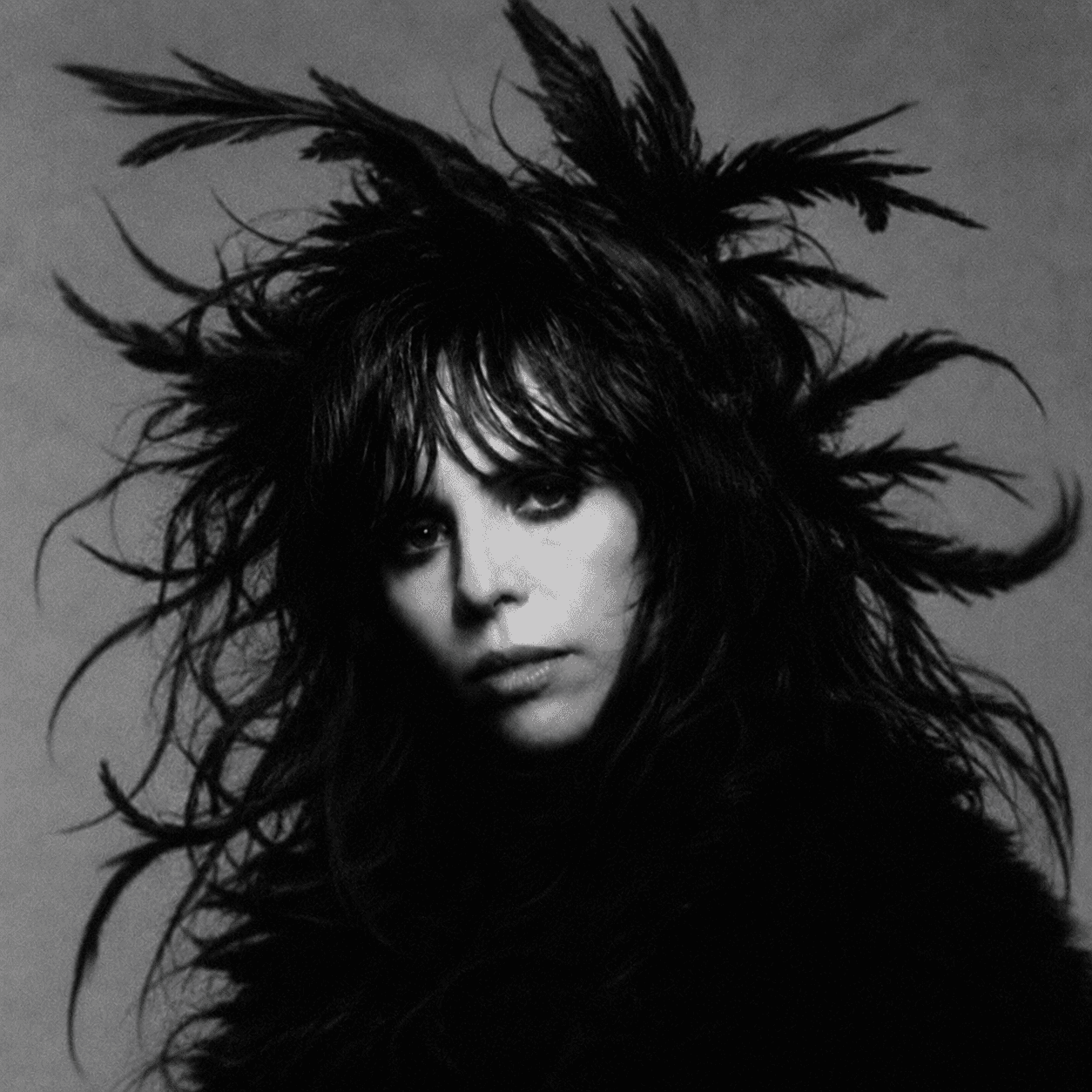 Editorial portrait of EMINATR1X wearing a feather crown